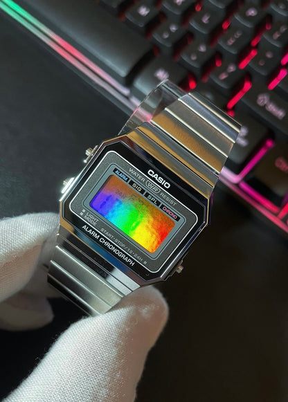 Clockwork Enigma custom vintage digital watch with a stainless steel band and orange holographic display, inspired by retro Casio designs